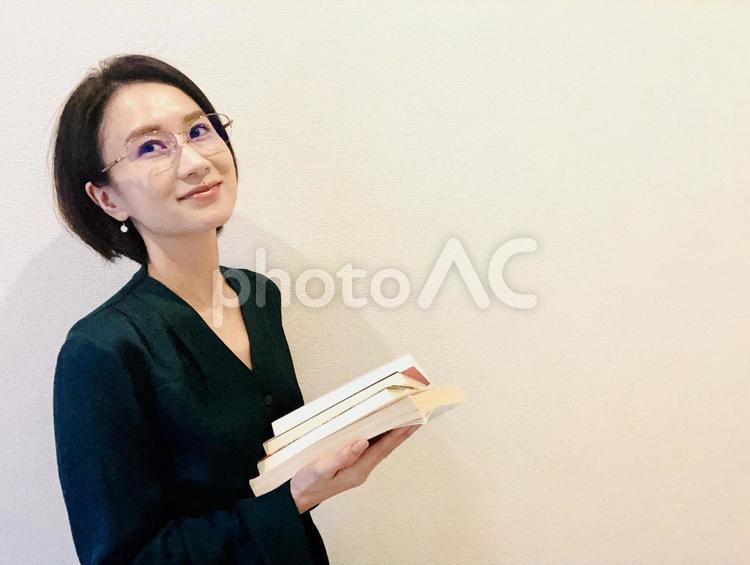本を持ちながら考え事をするメガネの女性 秋,読書,読書の秋の写真素材