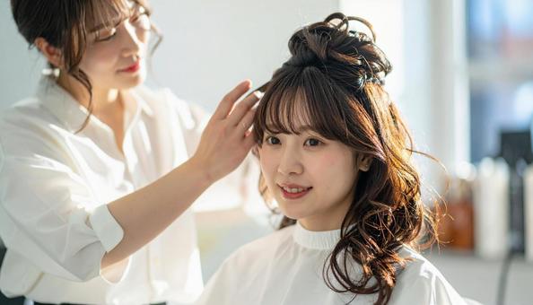 美容室の女性美容師が女性客の長い髪を触る 美容室の女性美容師が女性客の長い髪を触るの写真