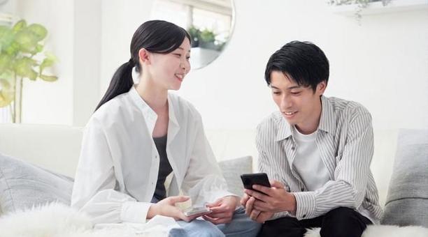 笑顔でスマホを見るアジア人カップル 笑顔でスマホを見るアジア人カップル スマートフォン,スマホ,見るの写真素材