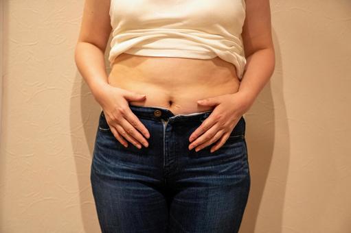 お腹の脂肪でパンツのチャックが閉まらない ダイエット,セルライト,脂肪燃焼の写真素材