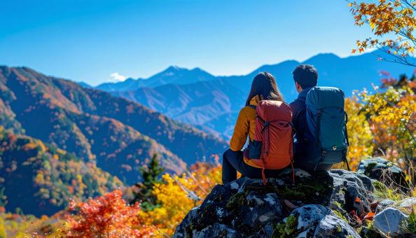 登山の途中に休憩するカップル 登山の途中に休憩するカップルの写真