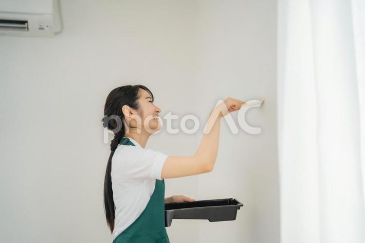 壁の塗装する女性（笑顔） 塗装,リフォーム,リノベーションの写真素材