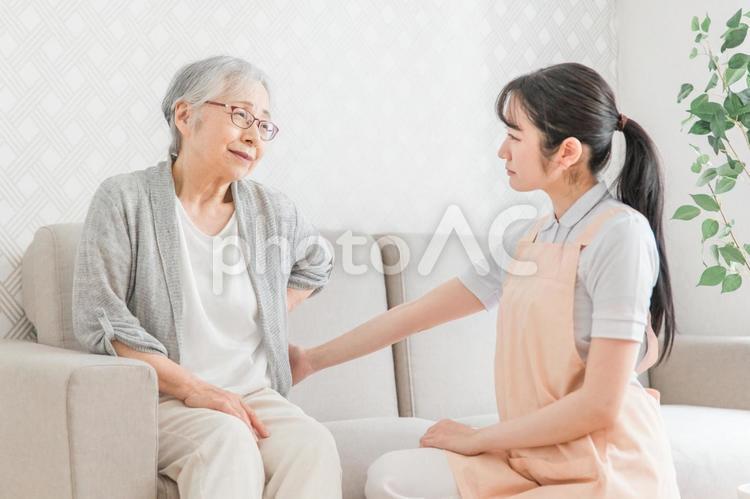 訪問介護・腰をおさえる高齢者女性（腰痛） 訪問介護,腰痛,在宅介護の写真素材