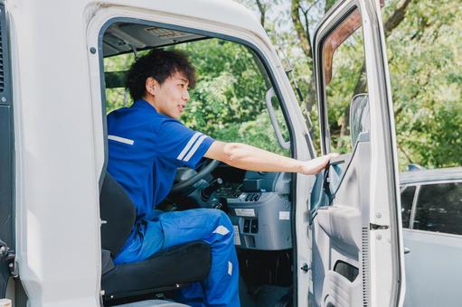 トラックに乗って仕事する作業服の男性 トラックに乗って仕事する作業服の男性 トラック,トラック男性,作業着の写真素材