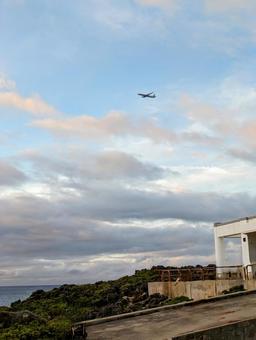 夕暮れ時の残波岬と飛行機 夕暮れ時の残波岬と飛行機 沖縄,沖縄旅行,残波岬の写真素材