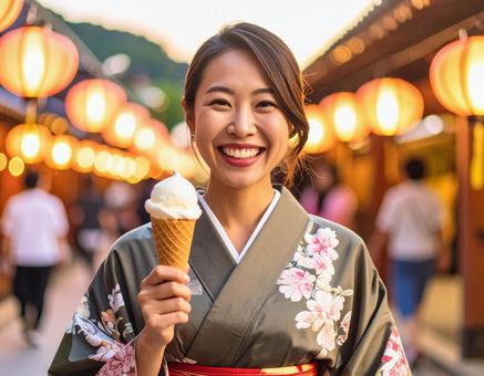 夏祭りでアイスを手に笑顔の浴衣姿女性 夏祭りでアイスを手に笑顔の浴衣姿女性の写真
