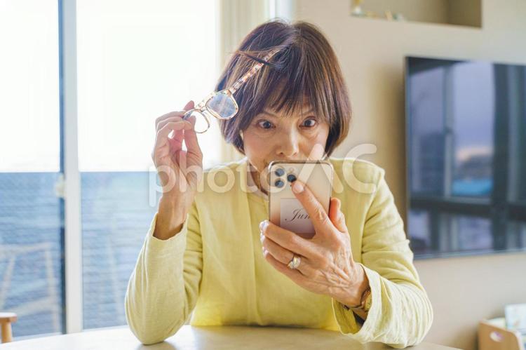 スマートフォンをながめて驚く女性 ビジネス,ビジネスウーマン,仕事の写真素材