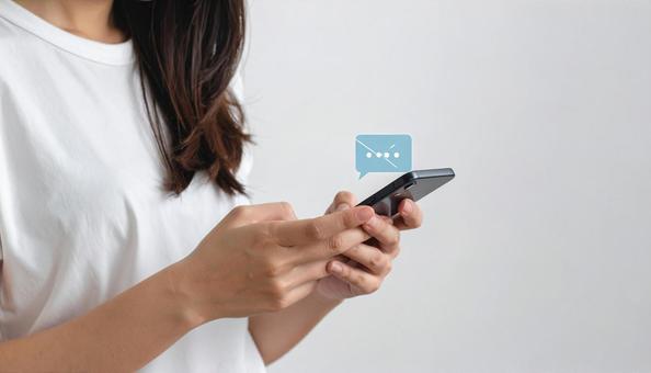 携帯電話でソーシャルメディアを楽しむ女性 携帯電話でソーシャルメディアを楽しむ女性の写真