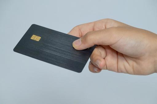 ブラックのICチップ付きカードを渡す手 カード,クレジットカード,icカードの写真素材