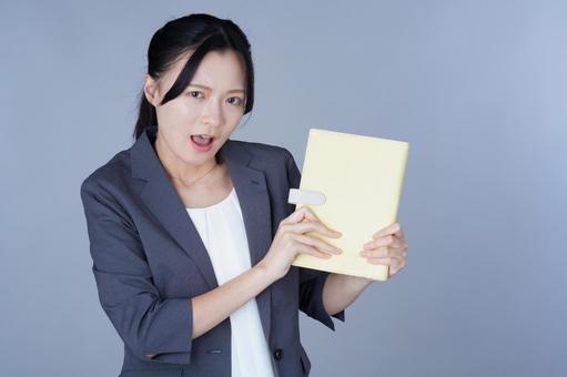 グレーの服の女性がノートを指差す 女性,ノート,持つの写真素材