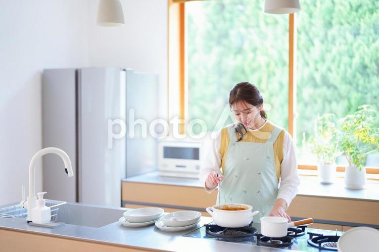 カレーの鍋を見つめる女性 女性,料理,母の写真素材