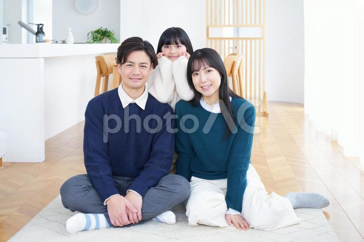 絨毯に座ってカメラ目線の家族 家族,男性,女の子の写真素材
