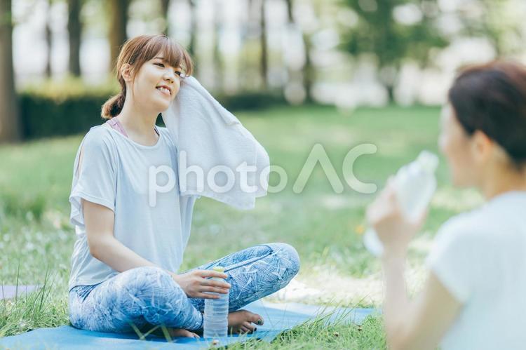 ヨガ教室で汗を拭いて休憩する女性 汗,水分補給,ヨガの写真素材