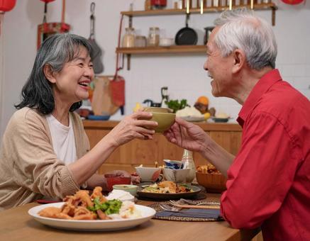 晩酌を楽しむ仲良しシニア夫婦 晩酌を楽しむ仲良しシニア夫婦の写真