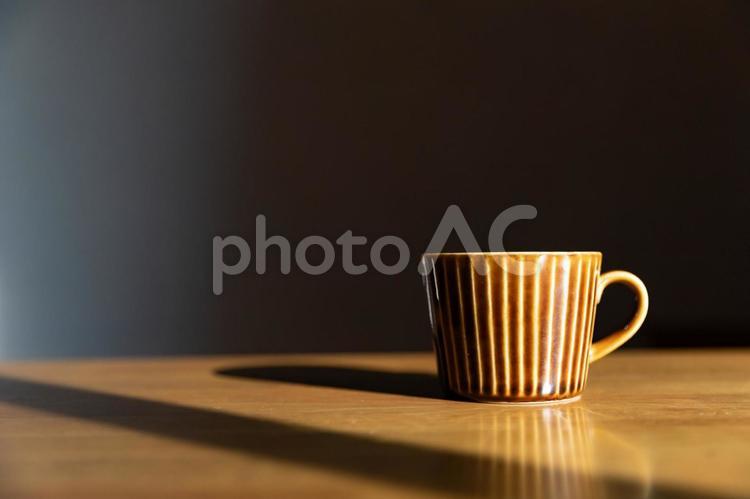 朝日を浴びるコーヒーカップと黒背景 コーヒー,カフェ,休憩の写真素材