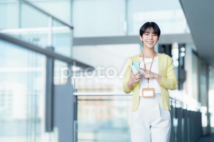 オフィスでスマホを見る女性エンジニア ビジネス,エンジニア,ビジネスマンの写真素材