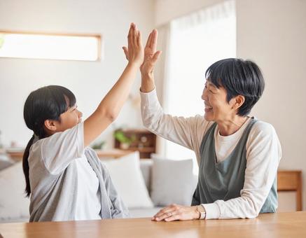 ハイタッチするおばあちゃんと孫 ハイタッチするおばあちゃんと孫の写真