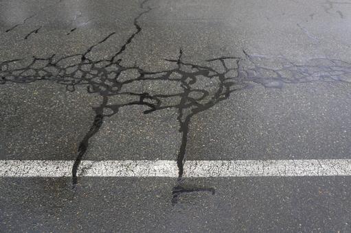 アスファルトのヒビ割れ補修（雨）01 アスファルト,道路,ヒビ割れの写真素材
