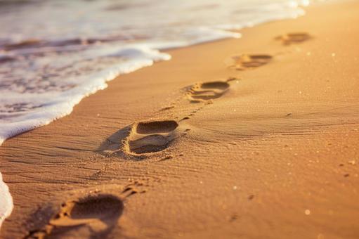 夕暮れの砂浜に残る足跡の写真