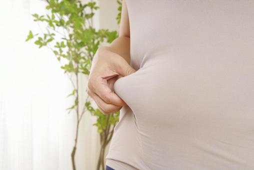 お腹周りの皮下脂肪を気にする中年女性 お腹,脂肪,皮下脂肪の写真素材