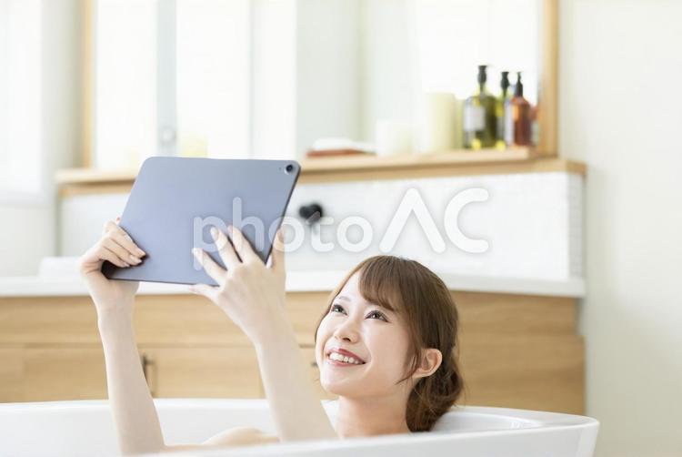 お風呂に浸かりながら動画を楽しむ女性 女性,人物,タブレットの写真素材