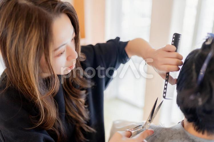 客の後ろをカットして整える女性美容師 ビジネス,ビジネスウーマン,キャリアウーマンの写真素材