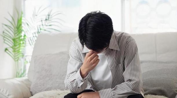 ソファで落ち込むアジア人男性 男性,落ち込む,ショックの写真素材