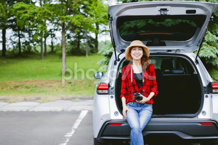 車とカメラを持つ女性 カメラ,一眼レフ,ドライブの写真素材