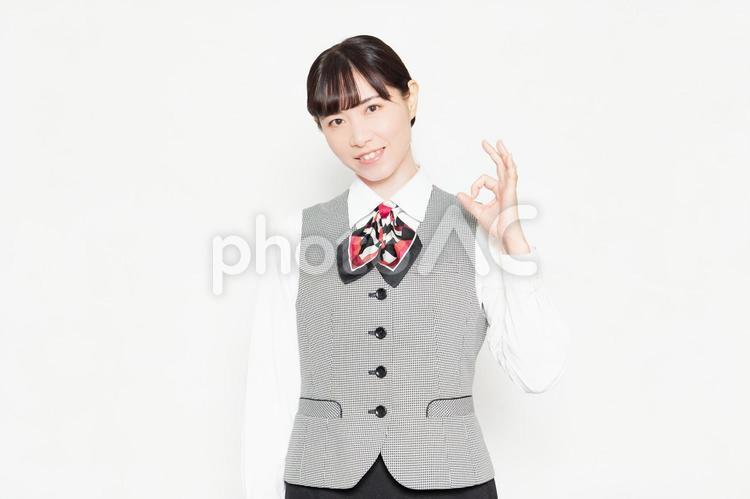 白い背景の前に立ってOKのジェスチャーをするビジネスウーマン ok,大丈夫,安心の写真素材