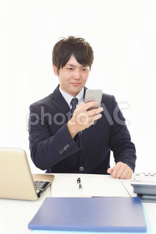 スマートフォンを持つ笑顔のビジネスマン 男性,ビジネスマン,男の写真素材