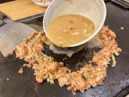 もんじゃ焼きを作っているシーン もんじゃ焼きを作っているシーンの写真