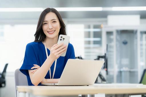 オフィスカジュアルの若い女性エンジニア オフィスカジュアルの若い女性エンジニア ビジネス,女性,スマホの写真素材