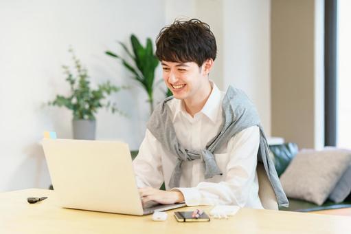 A young man using a laptop in a casual space A young man using a laptop in a casual space
