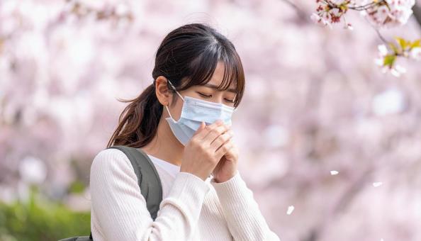 マスクをして辛そうにしている日本人女性の写真