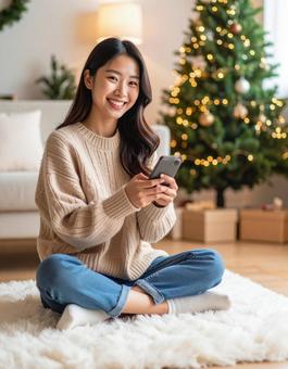 クリスマスの部屋でスマホを楽しむ女性 クリスマスの部屋でスマホを楽しむ女性の写真