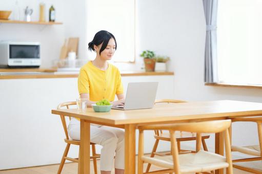ダイニングテーブルでパソコン作業をする女性 女性,ノートパソコン,ライフスタイルの写真素材