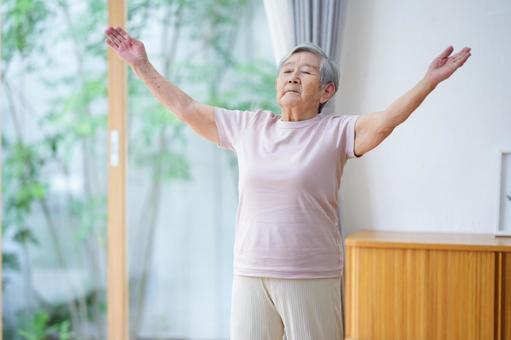 両手を広げて上を見る高齢女性 女性,両手を広げる,目を瞑るの写真素材