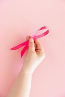 ピンクリボンを持つ女性の手 手,手のみ,手元の写真素材
