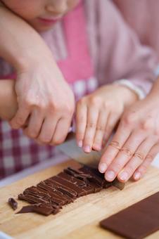 包丁を慎重に扱う親子の手元 女の子,チョコレート,包丁の写真素材