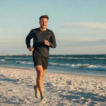 波打ち際を走る男性ランナー 波打ち際を走る男性ランナーの写真