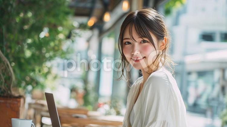 緑豊かなカフェでノートPCを使用する女性 カフェ,女性,緑の写真素材