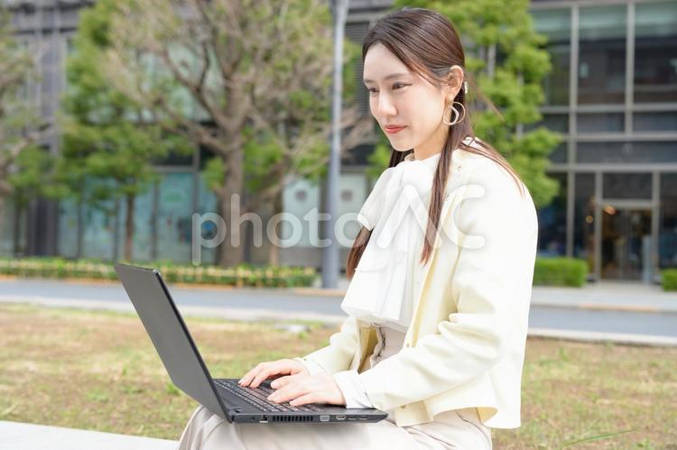 野外でパソコンを操作する日本人女性 日本人,40代,30代の写真素材