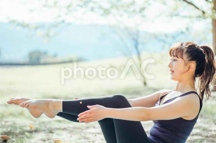 屋外でヨガをする女性（舟のポーズ） ヨガ,ダイエット,ピラティスの写真素材