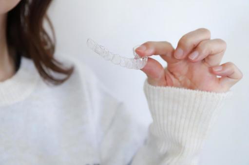 透明のマウスピースを持った女性 歯列矯正,矯正歯科,矯正の写真素材