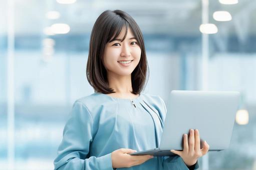 パソコンを持つ女性・ビジネスウーマン 女性,パソコン,笑顔の写真素材