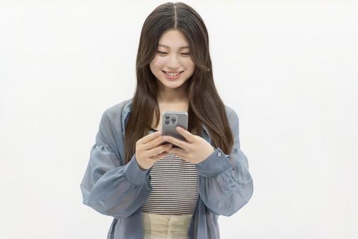 スマートフォンを使う若い女性 スマートフォンを使う若い女性 女性,スマホ,スマートフォンの写真素材