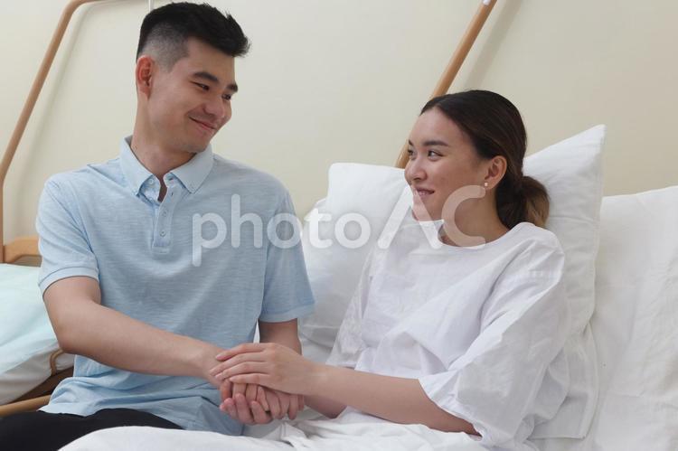 病院のベッドにいる女性と寄り添う男性2 入院,アジア人,外国人の写真素材