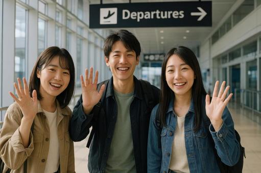 空港の出発口で手を振る日本の友人グループ 空港の出発口で手を振る日本の友人グループの写真