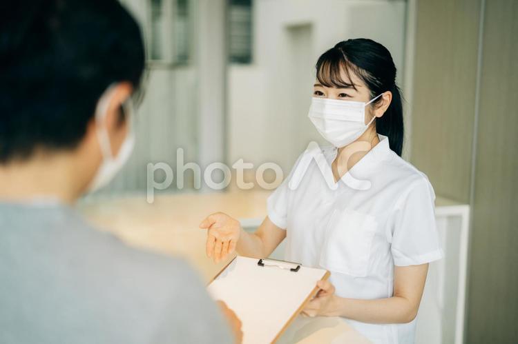 病院の受付にいる女性（マスク・患者） 医療事務,看護師,受付の写真素材
