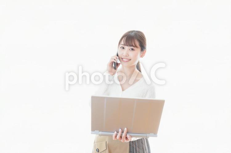 笑顔で在宅勤務をする若い女性 短縮,対策,緊急事態制限の写真素材